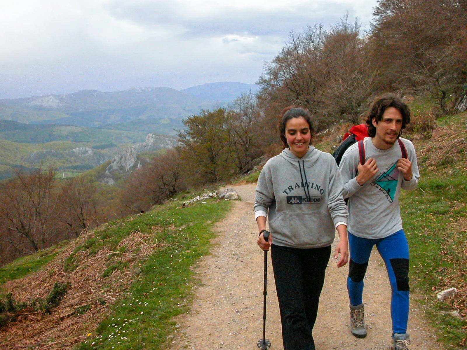 Dos personas caminando por un sendero de montaña
